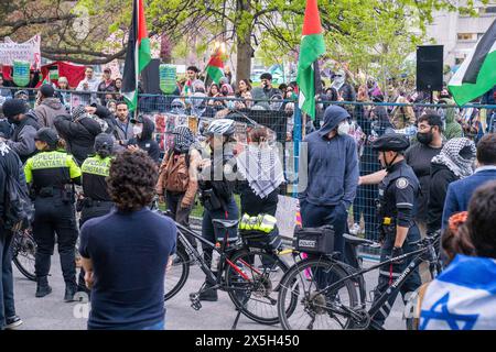 Die Polizei hat während der Demonstration eine menschliche Barrikade zwischen Pro-Israel und Pro-Palästinensern errichtet. Pro-palästinensische und pro-israelische Demonstranten an der University of Toronto außerhalb des Studentenlager im King College Circle. Studenten und Dozenten, die sich für die palästinensischen Rechte einsetzten, zeigten Banner, die die Not der Palästinenser darstellten, antizionistische und anti-israelische Botschaften, während pro-israelische Proteste Studenten und Unterstützer daran beteiligten, israelische Flaggen zu schwenken und Dialoge zu führen, um Israels Aktionen und Politik zu verteidigen. Stockfoto