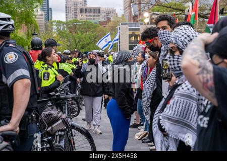 Die Polizei hat während der Demonstration eine menschliche Barrikade zwischen Pro-Israel und Pro-Palästinensern errichtet. Pro-palästinensische und pro-israelische Demonstranten an der University of Toronto außerhalb des Studentenlager im King College Circle. Studenten und Dozenten, die sich für die palästinensischen Rechte einsetzten, zeigten Banner, die die Not der Palästinenser darstellten, antizionistische und anti-israelische Botschaften, während pro-israelische Proteste Studenten und Unterstützer daran beteiligten, israelische Flaggen zu schwenken und Dialoge zu führen, um Israels Aktionen und Politik zu verteidigen. Stockfoto