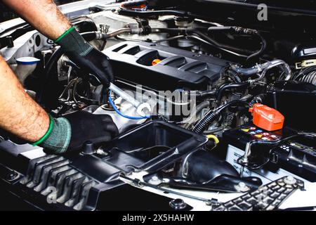 Kfz-Mechaniker mit Schraubenschlüssel zur Reparatur des Kfz-Motors , Kfz-Wartungskonzept Stockfoto