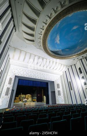 Ein Blick auf die Sitzplätze im Auditorium, mit Blick auf die runde, kreisförmige blaue Himmelsmalerei an der Decke. Am usbekischen National Academic Drama Theatre in Taschk Stockfoto