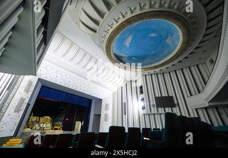 Ein Blick auf die Sitzplätze im Auditorium, mit Blick auf die runde, kreisförmige blaue Himmelsmalerei an der Decke. Am usbekischen National Academic Drama Theatre in Taschk Stockfoto