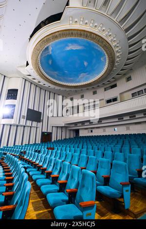 Ein Blick auf die Sitzplätze im Auditorium, mit Blick auf die runde, kreisförmige blaue Himmelsmalerei an der Decke. Am usbekischen National Academic Drama Theatre in Taschk Stockfoto