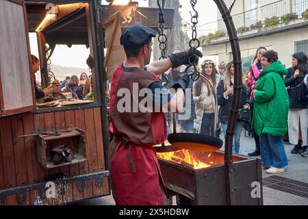 Baiona, Pontevedra, Galicien, Spanien; März 2023; ein mittelalterlicher Koch macht Pfannkuchen mit Feuer vor dem aufmerksamen Blick der Menschen Stockfoto
