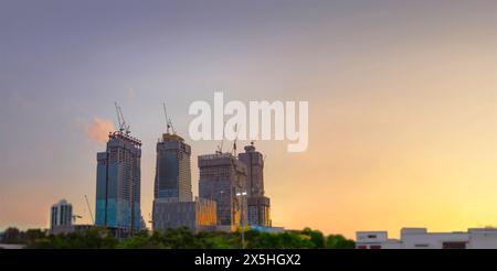 Der Wippturmkran am schmalen Baustellengebäude am Abend Stockfoto