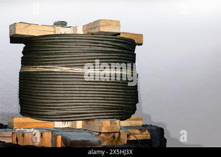 Die Schlinge wurde in der Trommel gelagert und lag neben der Wand. Das Seil des Turmkrans, das für die Montage am Turmkran vorbereitet wird. Stockfoto