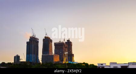 Der Wippturmkran am schmalen Baustellengebäude am Abend Stockfoto