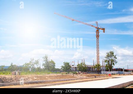 Der Betreiber bediente den Turmkran auf der Baustelle, um das Gebäude und die Eigentumswohnungen zu erstellen. Und Sonnenschein am Mittag. Stockfoto