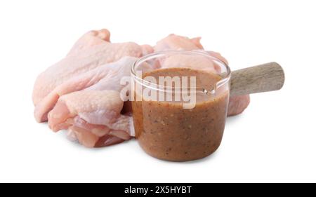 Frische Marinade und rohe Hähnchenflügel isoliert auf weiß Stockfoto