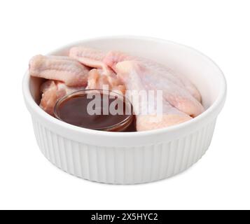 Frische Marinade und rohe Hähnchenflügel in einer Schüssel isoliert auf weiß Stockfoto