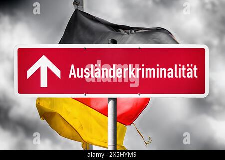 FOTOMONTAGE, Rotes Schild mit Aufschrift Ausländerkriminalität und steigendem Pfeil vor Deutschlandfahne Stockfoto