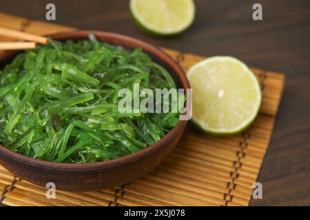 Leckerer Algensalat in der Schüssel, serviert auf Holztisch, Nahaufnahme Stockfoto