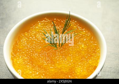 Frischer Hechtkaviar und Dill in Schüssel auf grauem Tisch, Nahaufnahme Stockfoto