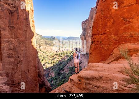 Frau, die auf einem Felsvorsprung steht und die malerische Landschaft überblickt Stockfoto