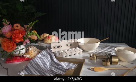 Elegante Backszene mit Blumen und Zutaten auf Marmorarbeitsfläche Stockfoto