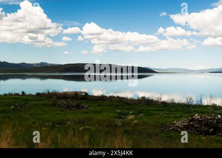 Friedliche Seenlandschaft mit reflektierendem blauem Wasser und Himmel. Stockfoto