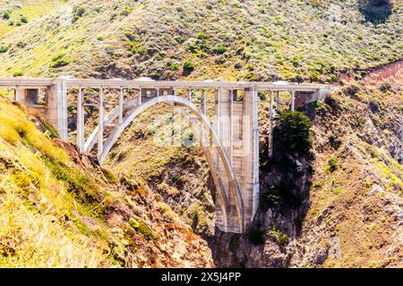 Die sonnenverwöhnte Bixby Bridge führt über einen üppigen Canyon in Big Sur. Stockfoto