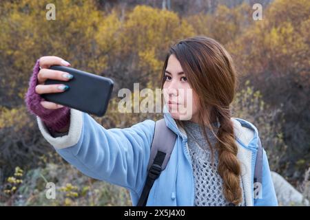 Frau macht ein Selfie im Wald Hintergrund Stockfoto