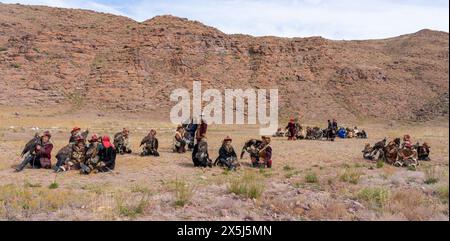 Asien, Mongolei, Provinz Bayan-Olgii. Beim Altai Eagle Festival sitzen Adlerjäger in Gruppen zusammen und warten auf den Wettbewerb, an dem sie teilgenommen haben. (Nur Für Redaktionelle Zwecke) Stockfoto