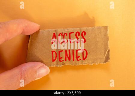 Zugriff verweigerte Wörter auf gerissenem Karton mit orangefarbenem Hintergrund. Symbol für konzeptionellen Zugriff verweigert. Kopierbereich. Stockfoto