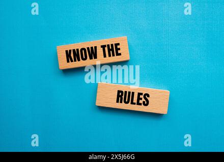 Kennen Sie die Regeln, die auf Holzblöcken mit blauem Hintergrund geschrieben sind. Das Symbol Regeln kennen. Kopierbereich. Stockfoto