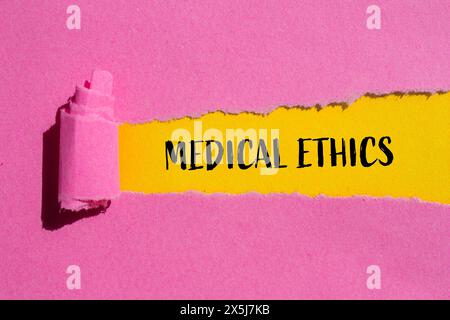 Medizinische Ethikworte auf gerissenem rosa Papier mit gelbem Hintergrund geschrieben. Konzeptuelles medizinisches Ethiksymbol. Kopierbereich. Stockfoto
