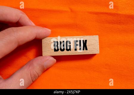Bugfix Wörter auf Holzblock mit orangem Hintergrund geschrieben. Symbol für konzeptionelle Fehlerbehebungen. Kopierbereich. Stockfoto