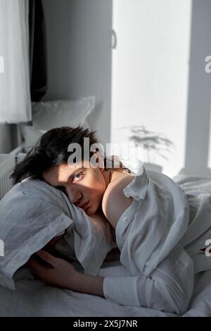 Ein verärgerter Mann, der in seinem Schlafzimmer auf dem Bett liegt und in die Kamera blickt. Depression, der Kerl hat Probleme mit der Freundin Stockfoto