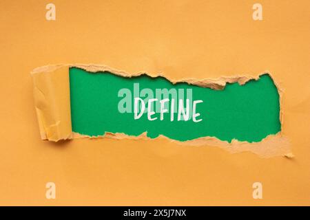 Definieren Sie das Wort, das auf gerissenem orangefarbenem Papier mit grünem Hintergrund geschrieben wird. Symbol für konzeptionelle Definition des Wortes. Kopierbereich. Stockfoto