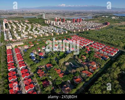 Wujiaqu. Mai 2024. Ein Luftbild der Drohne vom 9. Mai 2024 zeigt eine Stadtansicht von Wujiaqu, der autonomen Region Xinjiang Uygur im Nordwesten Chinas. In den letzten Jahren hat Wujiaqu, eine nationale Gartenstadt in der autonomen Region Xinjiang Uygur im Nordwesten Chinas, große Anstrengungen unternommen, um Ökologieprojekte zu fördern und die ökologische Umwelt zu optimieren. Bis Ende 2023 besaß Wujiaqu über 15.700 mu (etwa 1.046,7 Hektar) städtischer Grünflächen mit einer Grünflächenabdeckung von mehr als 45 Prozent. Quelle: Hu Huhu/Xinhua/Alamy Live News Stockfoto