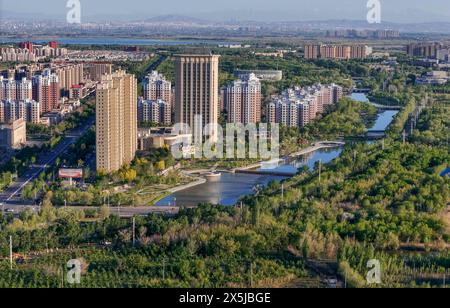 Wujiaqu. Mai 2024. Ein Luftbild der Drohne vom 9. Mai 2024 zeigt eine Stadtansicht von Wujiaqu, der autonomen Region Xinjiang Uygur im Nordwesten Chinas. In den letzten Jahren hat Wujiaqu, eine nationale Gartenstadt in der autonomen Region Xinjiang Uygur im Nordwesten Chinas, große Anstrengungen unternommen, um Ökologieprojekte zu fördern und die ökologische Umwelt zu optimieren. Bis Ende 2023 besaß Wujiaqu über 15.700 mu (etwa 1.046,7 Hektar) städtischer Grünflächen mit einer Grünflächenabdeckung von mehr als 45 Prozent. Quelle: Hu Huhu/Xinhua/Alamy Live News Stockfoto