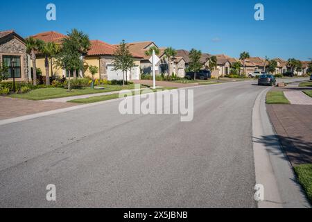 Lakewood Ranch, FL, USA-15. September 2022: Häuser am See in der oberen Mittelschicht mit Palmen und blauem Himmel. Stockfoto