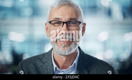 Porträt eines erfolgreichen mittelalten bärtigen Mannes, der die Kamera ansieht und lächelt. Gutaussehender Geschäftsmann, Der Jacke Trägt Und Spaß Hat. Nahaufnahme Stockfoto