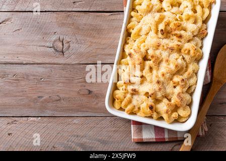 Traditioneller südlicher Mac und Käse mit Brotkrumen auf Holzhintergrund, Blick von oben, Kopierraum. Käse-cremiger Nudelauflauf mit Fleisch. Stockfoto