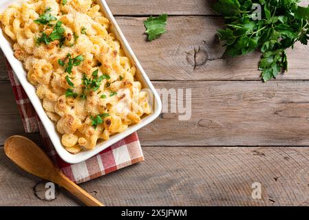 Traditioneller südlicher Mac und Käse mit Brotkrumen auf Holzhintergrund, Blick von oben, Kopierraum. Hausgemachter Käse- und cremiger Nudelauflauf mit Fleisch. Stockfoto