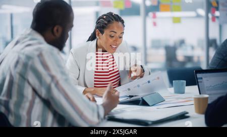 In Diversity Modern Office: Geschäftstreffen erfolgreicher schwarzer Geschäftsfrau und afroamerikanischer Geschäftsmann, Talk, Smile. Kreative digitale Unternehmer arbeiten am E-Commerce-Projekt. Stockfoto
