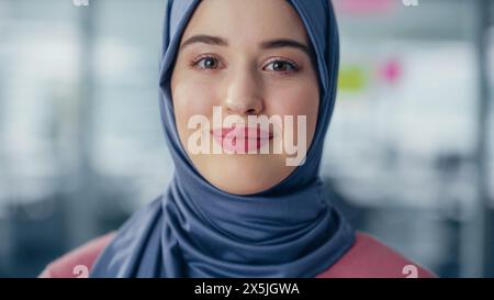 Nahaufnahme Porträt einer muslimischen Geschäftsfrau, die Hijab trägt, Blick auf Kamera und Lächeln. Schöne Frau Mit Traditionellem Kopftuch. Erfolgreiche Befähigte Arabische Frau. Stockfoto