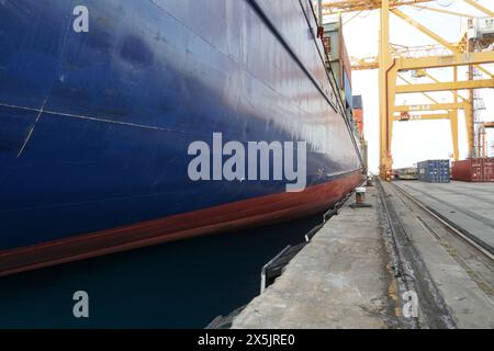 Blauer Rumpf des Containerschiffs, der im Hafen von Bridgetown, Barbados, einer Insel der Karibik, vor Anker liegt. Stockfoto