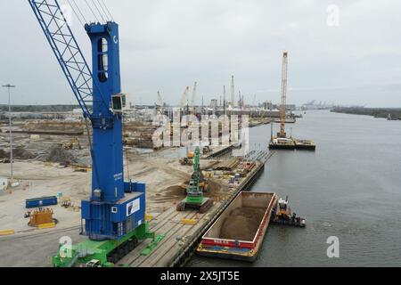 Lastkahn mit Schlepper, blauem Mobilkran und anderen schweren Industriemaschinen, die in einem neuen Containerterminal in Savannah im Bau sind, Stockfoto