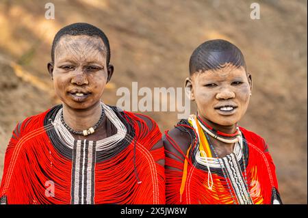 Mundari-Frauen in traditionellen Kleidern mit Narbenbildung und Asche auf Gesichtern, posieren auf einem Felsen, Mundari-Stamm, Südsudan, Afrika Copyright: MichaelxRu Stockfoto