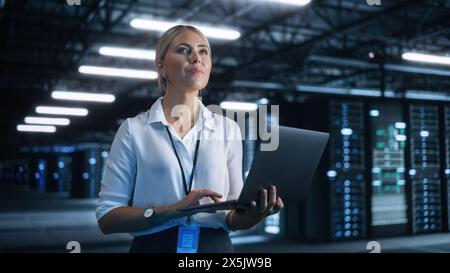 Porträt einer erfolgreichen Chefingenieurin oder CEO, die einen Laptop zur Optimierung der Cloud Computing-Einrichtung der Server Farm im Evening Office nutzt. Cyber Security, Network Protection Concept Stockfoto