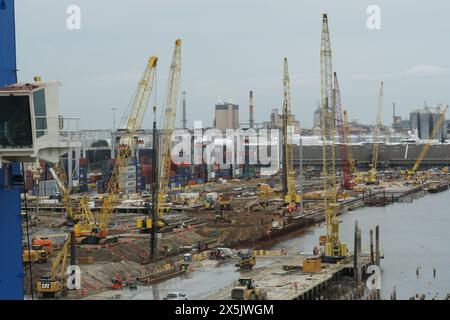 Verschiedene Kräne und schwere Industriemaschinen werden in einem neuen Containerterminal eingesetzt, das im Bau an einem Fluss in der amerikanischen Stadt Savannah ist. Stockfoto