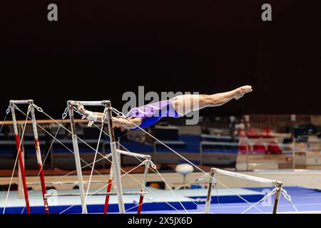 Frauengymnastik auf unebenen Bars Gymnastik auf schwarzem Hintergrund Stockfoto