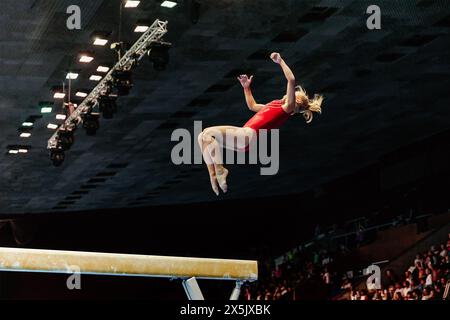Übung zum Balancebalken Gymnastik, weibliche Turnerin führen rückwärts Somersault Landung auf dem Boden Stockfoto