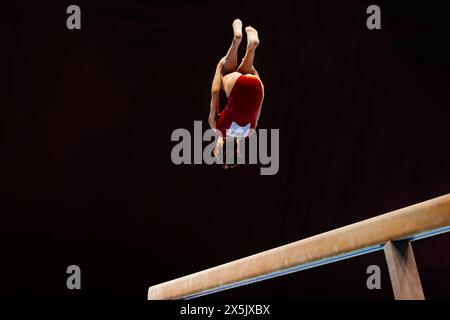 Weibliche Turnerinnen führen Rückwärtstraining auf Gleichgewichtsstrahmen durch Stockfoto