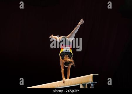 Die Turnerin führt Handstand auf Balancebalken-Gymnastik durch Stockfoto