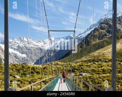 Eine schwingende Brücke und Bergblick auf dem Hooker Valley Trail im Aoraki Mount Cook Nationalpark, UNESCO-Weltkulturerbe, Südalpen, Südinsel Stockfoto