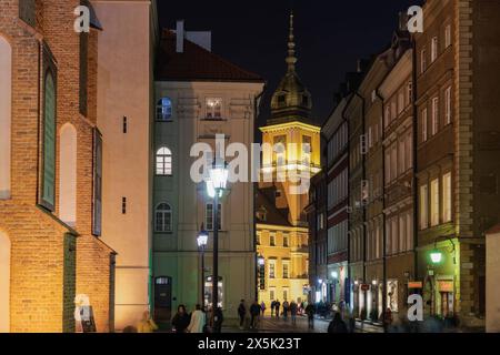 Flache Gebäude mit vorbeiziehender Menschenmenge in der Nähe des Schlossplatzes Plac Zamkowy, der historischen Straße Swietojanska bei Nacht, der Altstadt, Warschau, Polen, Europa C Stockfoto