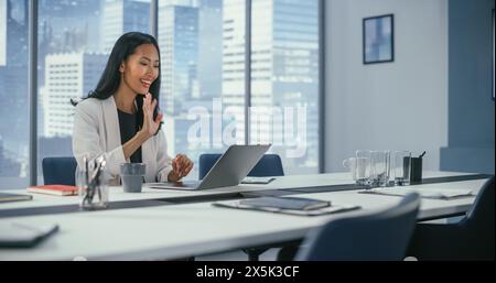 Office Video Call Conference: Porträt einer erfolgreichen asiatischen Geschäftsfrau im Gespräch mit Partnern über Laptop-Computer. Online-Meeting der leistungsstarken CEO-Diskussion über das digitale E-Commerce-Projekt. Stockfoto