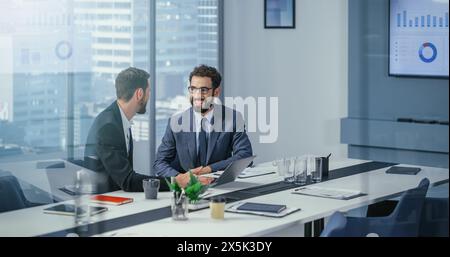 Geschäftsleute im modernen Büro: Geschäftstreffen zweier Geschäftsleute im Gespräch. CEO und Executive Strategy Brainstorming von Ideen für Investitionen in digitale E-Commerce-Software. Gutaussehende, Glückliche Profis Stockfoto
