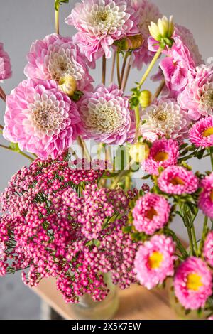 Ein Blumenstrauß aus rosa und weißen Blumen in einer Vase auf einem Tisch Stockfoto